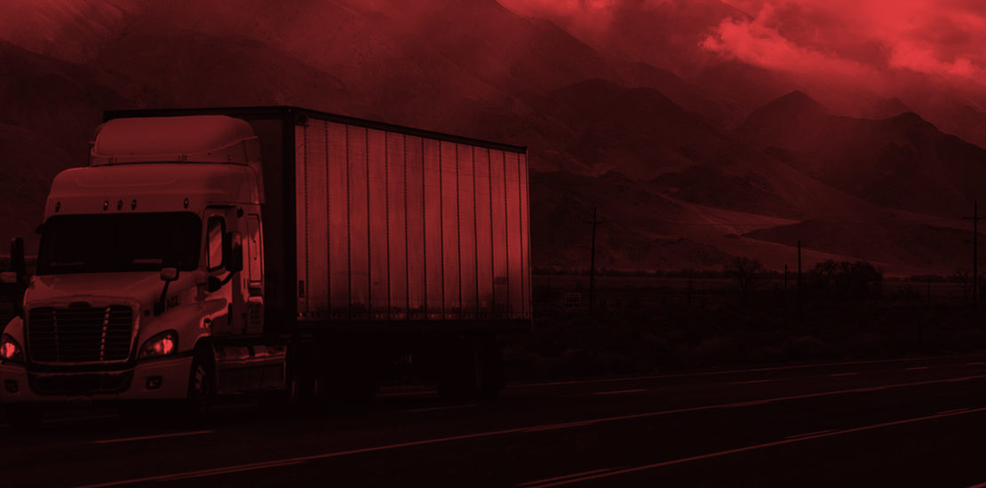 semi truck on road with mountains behind with red overlay