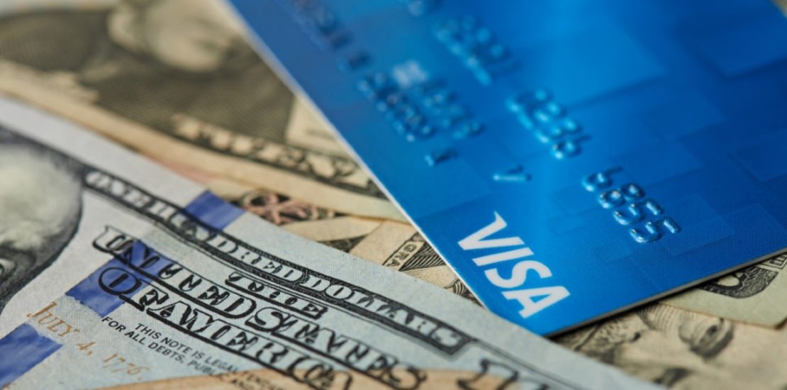 close up of paper money and blue credit card