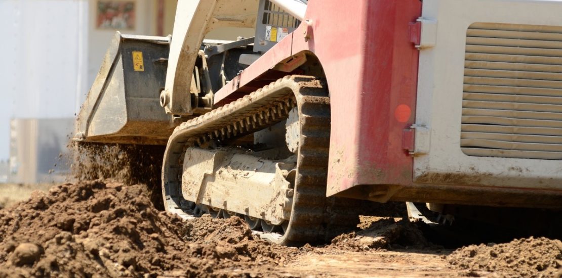 track loader scooping dirt