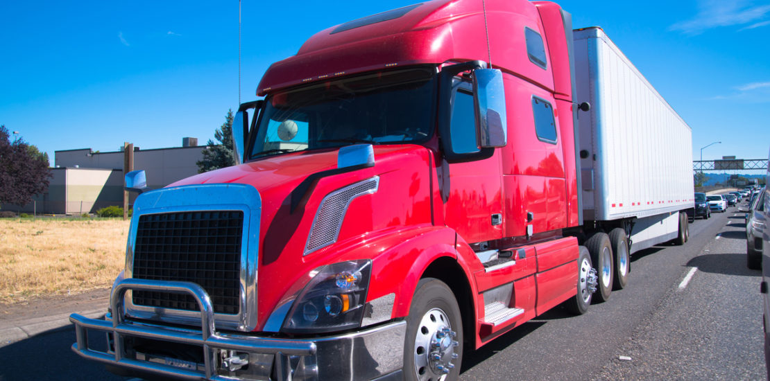 Red fancy big rig semi truck modern trailer interstate highway